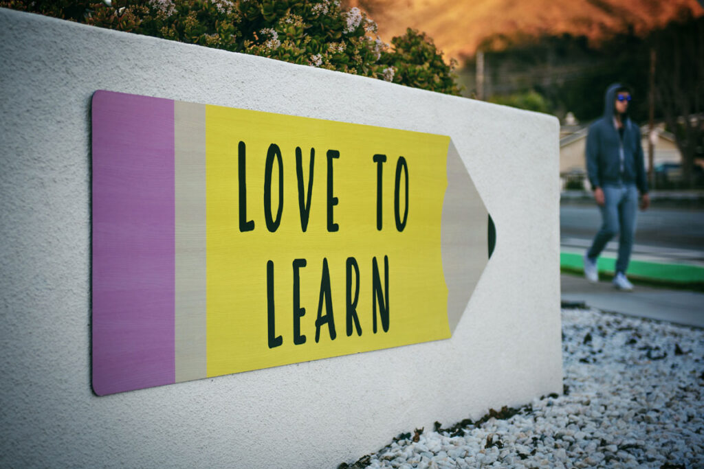 Wegweise-Schild in Form eines Bleistifts mit der Aufschrift "Love to Learn"