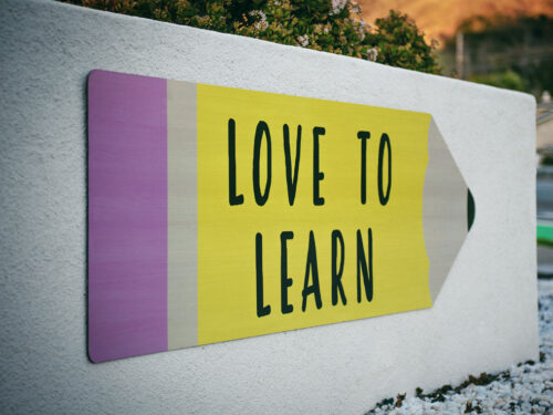 Wegweise-Schild in Form eines Bleistifts mit der Aufschrift "Love to Learn"